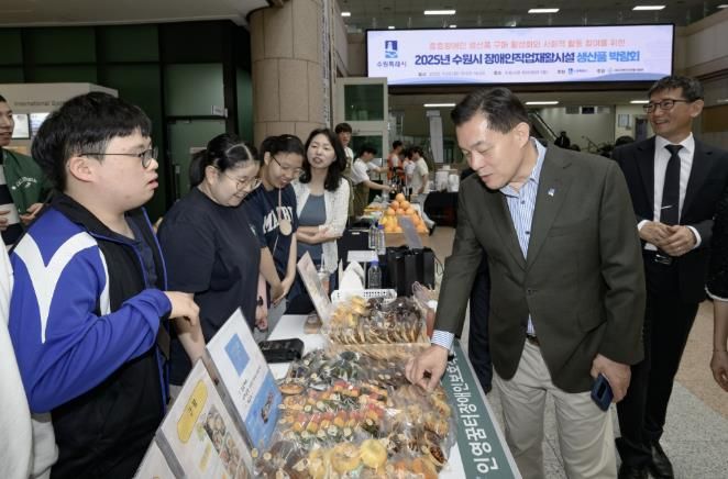 이재준 수원시장이 박람회에 출품한 물품을 살펴보고 있다.
