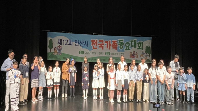 제12회 안산시 전국가족동요대회 참가자들이 무대에서 기념촬영을 하고 있다.